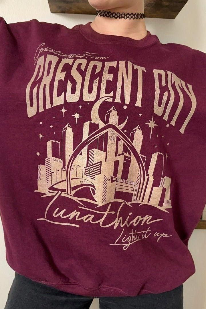 Greetings From Crescent City Sweatshirt — Crescent City merch by Sarah J. Maas. The postcard from the city of Bryce and Hunt. Hand-designed in Australia, officially licensed.