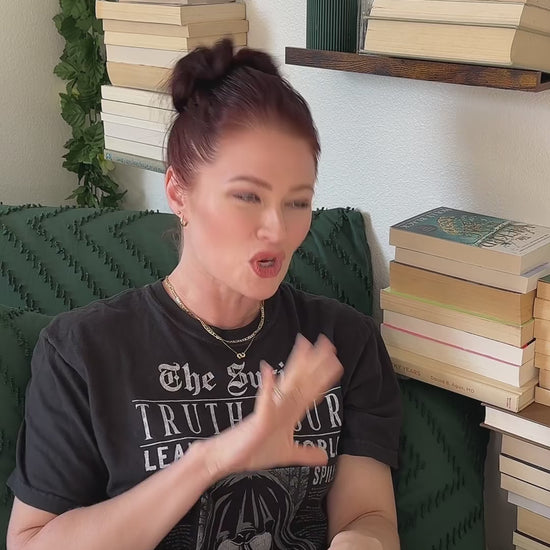 Lifestyle video: the black Suriel t-shirt worn while reading — 'The Suriel / TRUTH TOUR / LEAVE THIS WORLD' above the hooded skull, 'a better place than you found it' along the hem [focal 50 55]