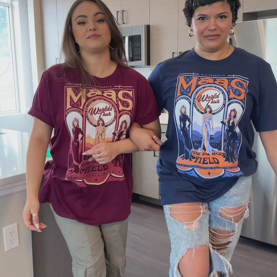 Try-on video: the maroon Maasverse t-shirt worn alongside the navy — the art-nouveau tour-poster print with MAAS, the World Tour roundel, the three figures and 'you do not yield' [focal 50 40]