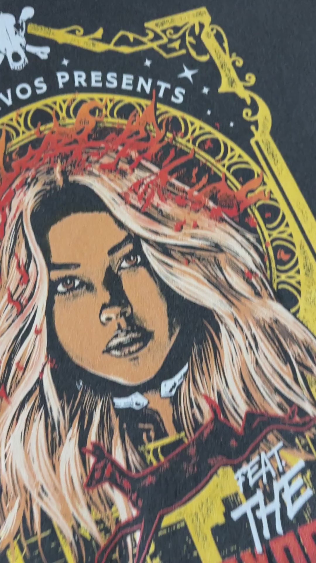 Product video: the Lidia Cervos t-shirt in close — the yellow art-nouveau frame around her portrait, 'LIDIA CERVOS PRESENTS' above and 'AGENT DAYBRIGHT' beneath [focal 50 45]