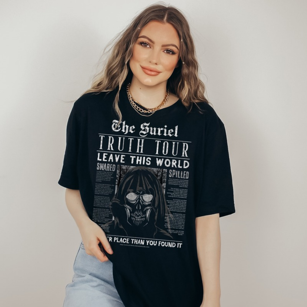 The Suriel T-Shirt in black on a model — 'Truth Tour, Leave This World' newspaper print. ACOTAR merch.