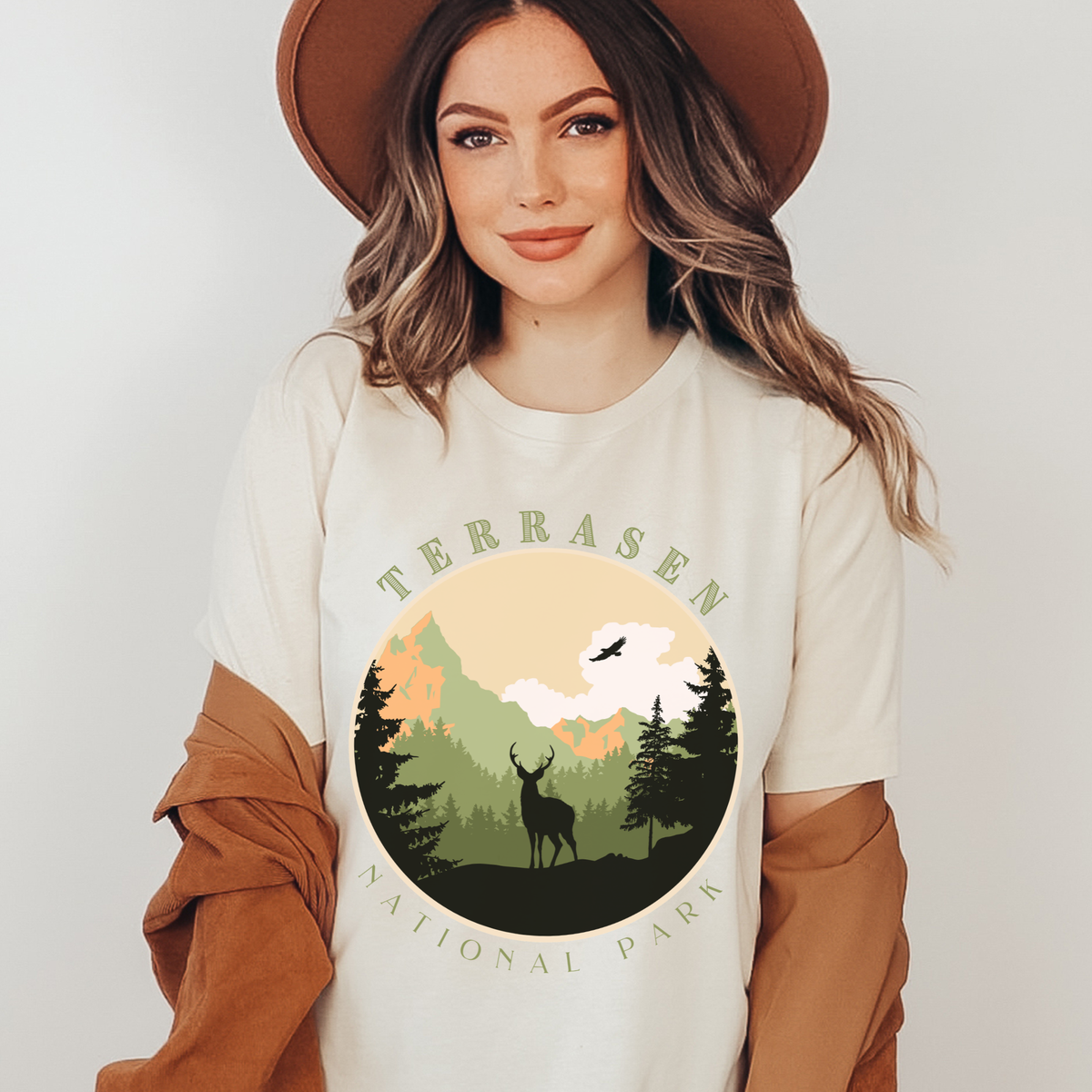 Model wearing the soft cream Terrasen National Park t-shirt — Throne of Glass merch inspired by Sarah J. Maas